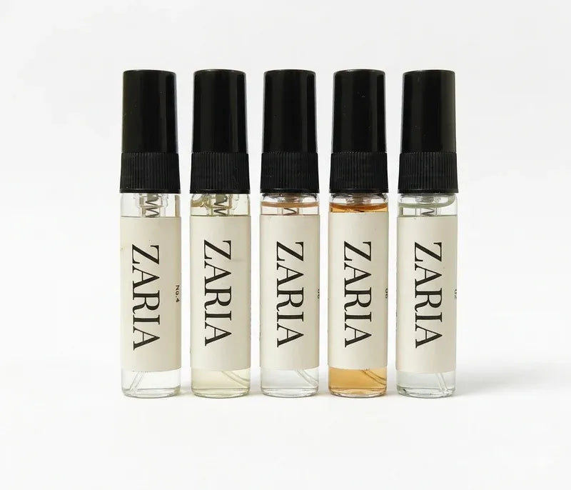 Five Zaria perfume bottles of different colors on a white background