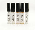 Five Zaria perfume bottles with black caps on a white background